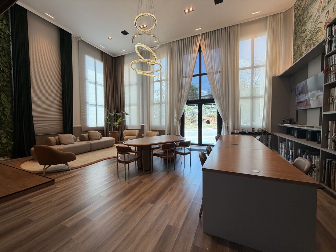 Showroom com mesa de atendimento e cortinas amplas